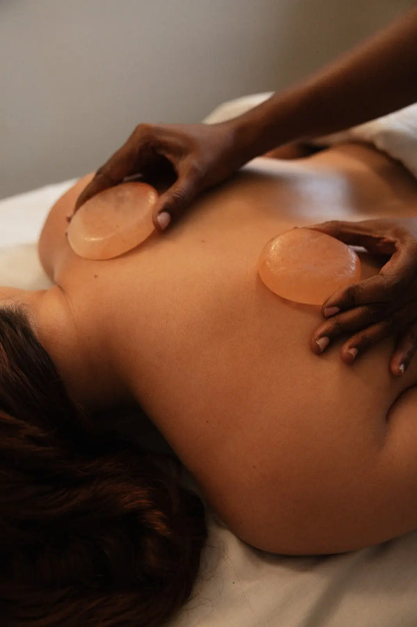 Massage therapist using Himalayan salt stones during a relaxing back massage